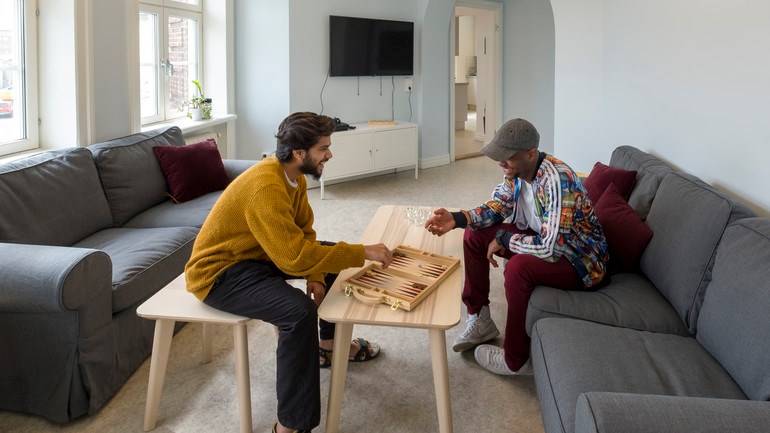 Two people playing games in Celsiusgården's common area.